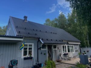Färdigställt mörkt plåttak på villa efter takarbete i Gävleområdet